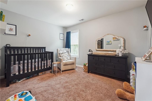 bedroom featuring carpet floors, a nursery area, baseboards, and visible vents