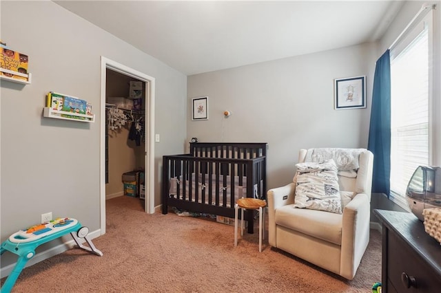 bedroom with a spacious closet, multiple windows, carpet, and baseboards