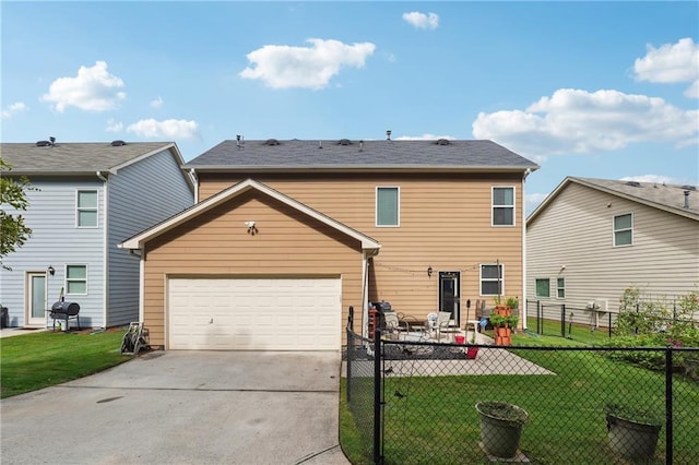 back of property featuring an attached garage, fence, a lawn, and concrete driveway