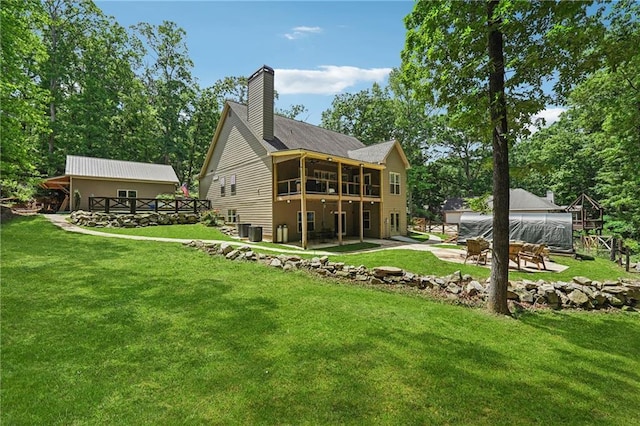 2945 Ashbyrn Ct, Buford, GA 30519 - back of property with a chimney, a lawn, a patio area, a sunroom, and a wooden deck