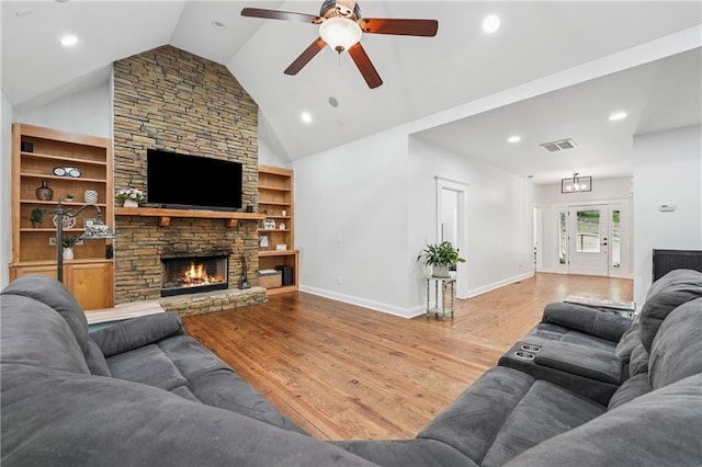2945 Ashbyrn Ct, Buford, GA 30519 - living room featuring wood finished floors, ceiling fan, a stone fireplace, lofted ceiling, and built in shelves