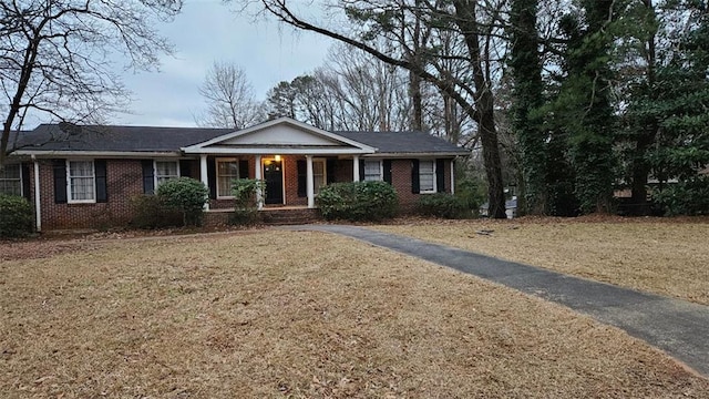 ranch-style home with a porch and a front yard