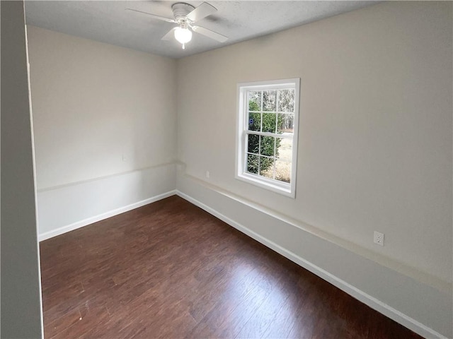 unfurnished room featuring ceiling fan, baseboards, and dark wood finished floors