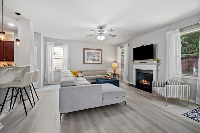 living room featuring plenty of natural light, ceiling fan, and light hardwood / wood-style floors