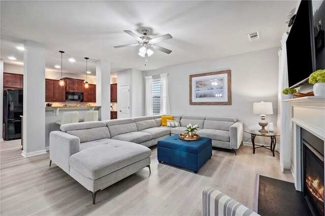 living room featuring light hardwood / wood-style flooring and ceiling fan