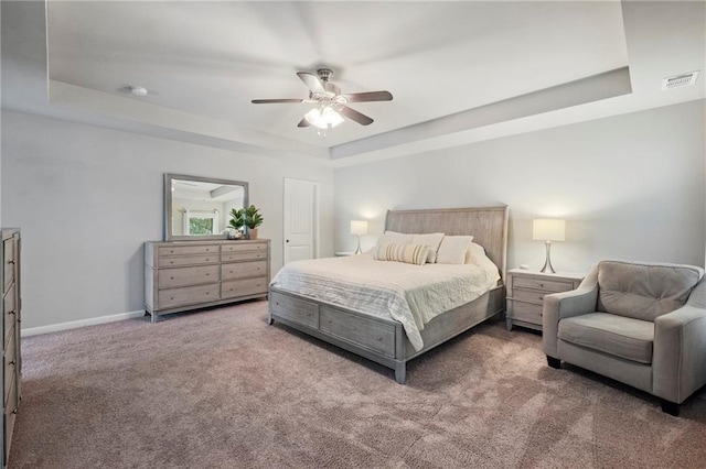 bedroom featuring a tray ceiling, ceiling fan, and carpet floors