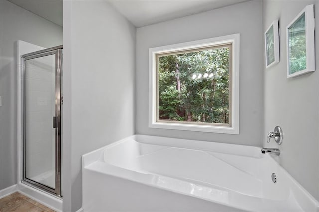 bathroom featuring tile patterned flooring and shower with separate bathtub