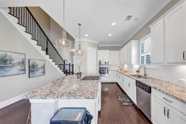 kitchen with a kitchen island, a breakfast bar area, white cabinets, and appliances with stainless steel finishes