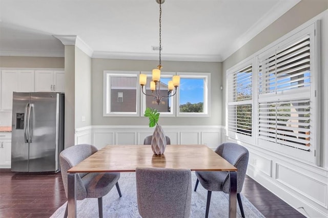 dining room with ornamental molding, dark hardwood / wood-style floors, and a chandelier