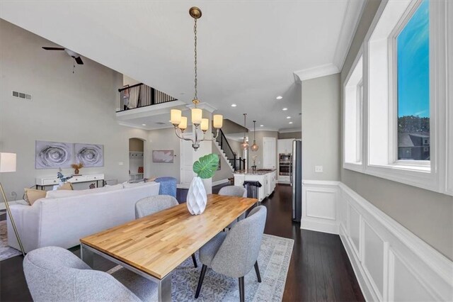 dining space with crown molding, dark wood-type flooring, and a notable chandelier