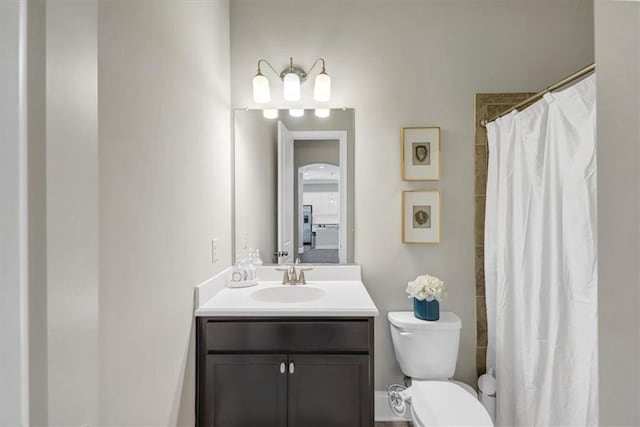 bathroom featuring vanity, curtained shower, and toilet