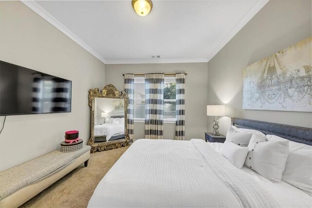 bedroom with ornamental molding and carpet floors