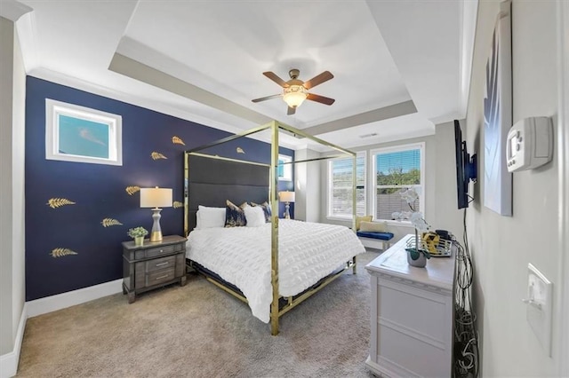 bedroom featuring ceiling fan, a raised ceiling, and light carpet