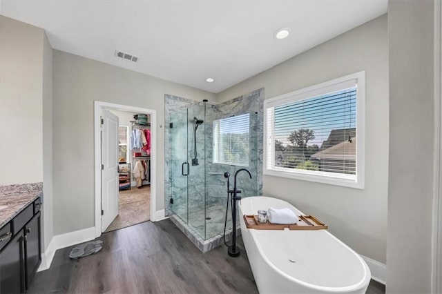 bathroom with vanity, hardwood / wood-style flooring, a wealth of natural light, and independent shower and bath