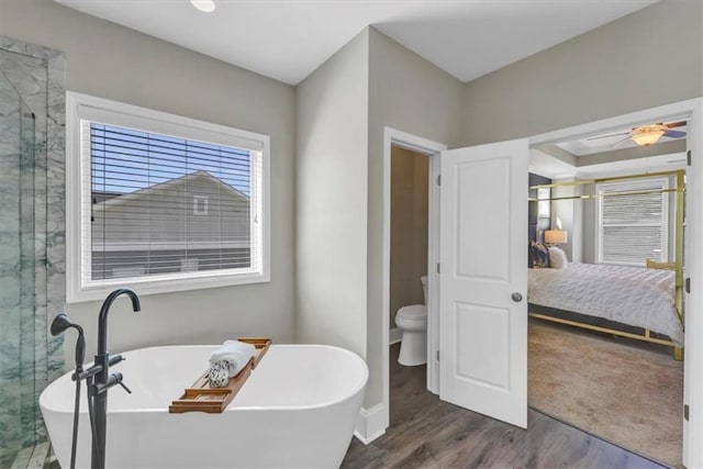 bathroom with independent shower and bath, hardwood / wood-style floors, ceiling fan, and toilet