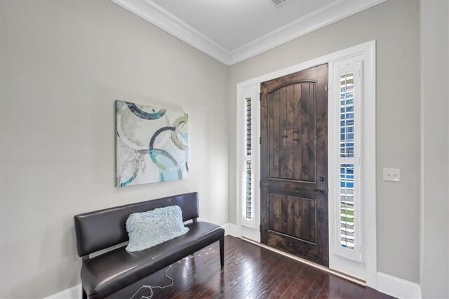 foyer entrance with plenty of natural light, ornamental molding, and dark hardwood / wood-style floors