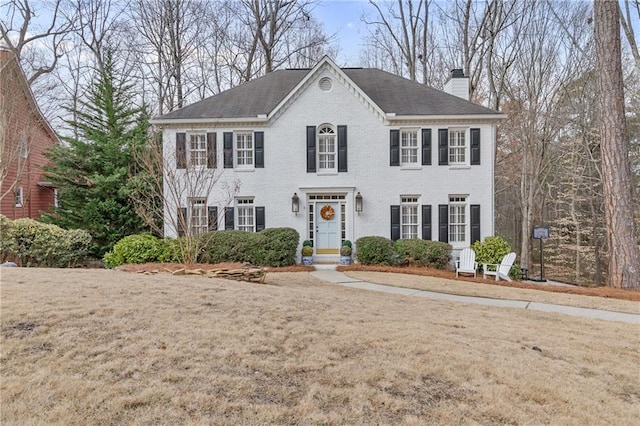 colonial inspired home featuring a front yard