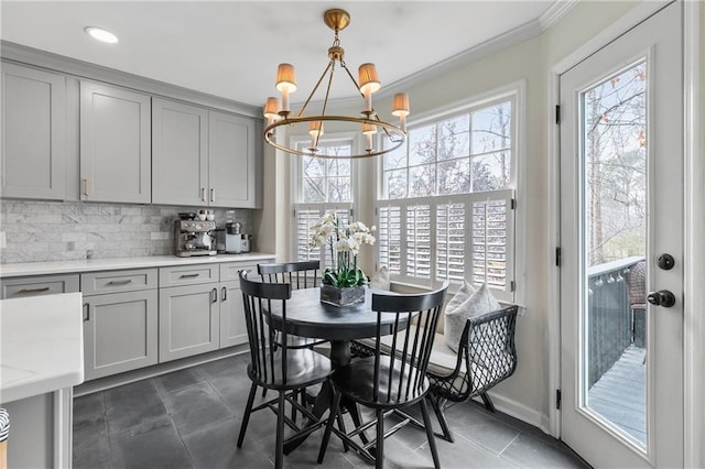 dining area with crown molding, plenty of natural light, and an inviting chandelier