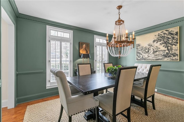 dining room featuring ornamental molding, a chandelier, and light wood-type flooring