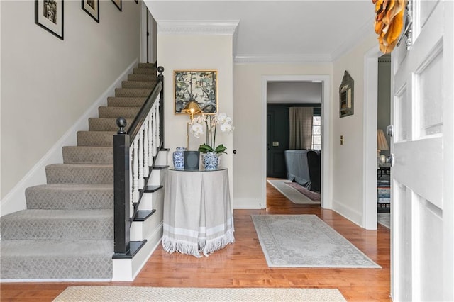 foyer entrance featuring wood-type flooring and crown molding