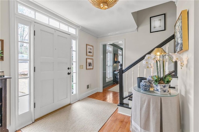 foyer entrance with wood-type flooring and ornamental molding