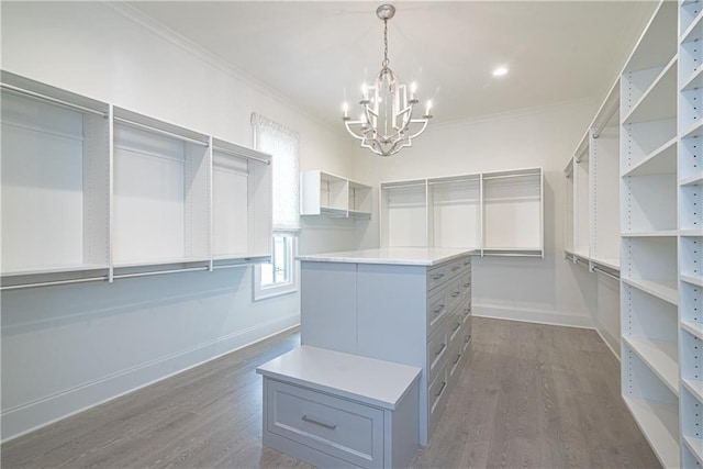 walk in closet featuring dark hardwood / wood-style floors and an inviting chandelier