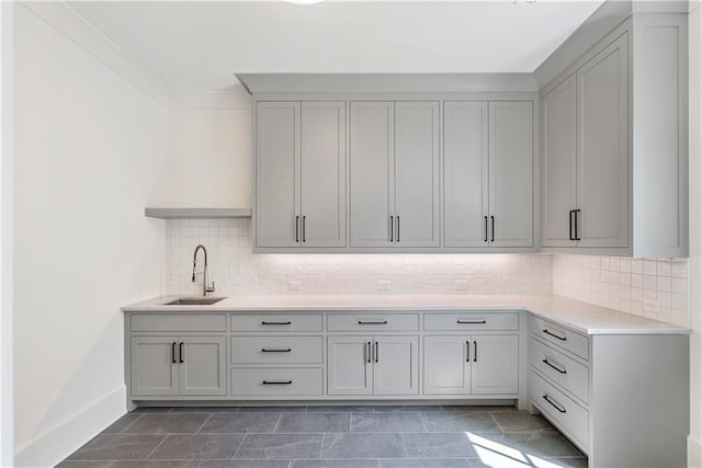 washroom featuring crown molding, sink, and dark tile patterned floors