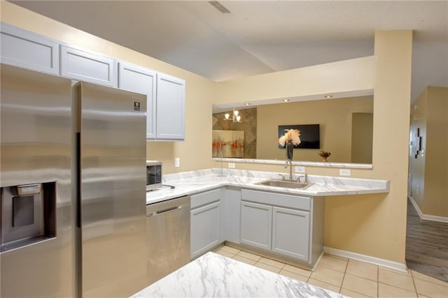 4938 Terrace Green Trce, Stone Mountain, GA 30088 - kitchen with appliances with stainless steel finishes, light tile patterned floors, a peninsula, lofted ceiling, and light stone counters