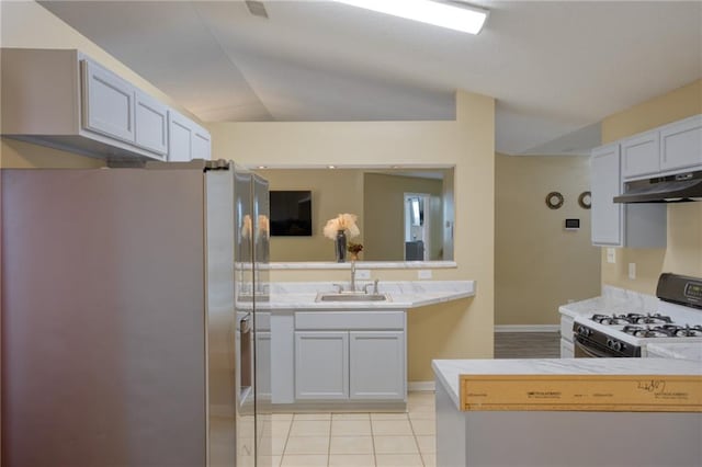 4938 Terrace Green Trce, Stone Mountain, GA 30088 - kitchen featuring freestanding refrigerator, under cabinet range hood, white range with gas cooktop, light tile patterned floors, and light countertops