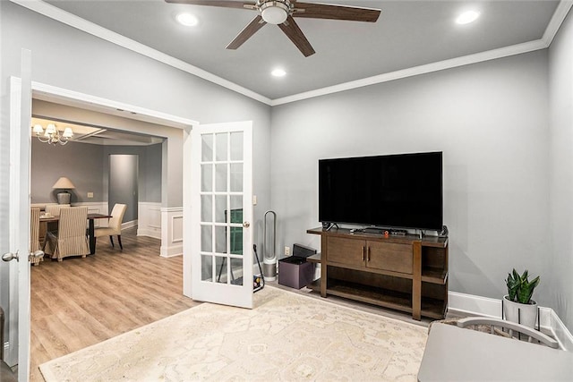 living room with crown molding, french doors, wood-type flooring, and ceiling fan with notable chandelier