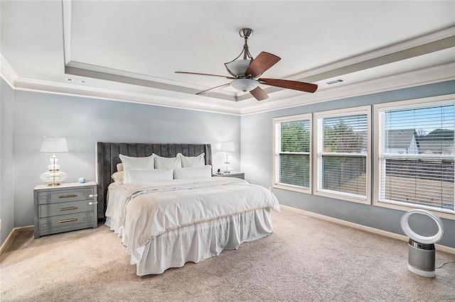 carpeted bedroom featuring a tray ceiling, ceiling fan, and ornamental molding