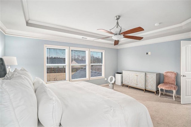 carpeted bedroom featuring ceiling fan, ornamental molding, and a tray ceiling