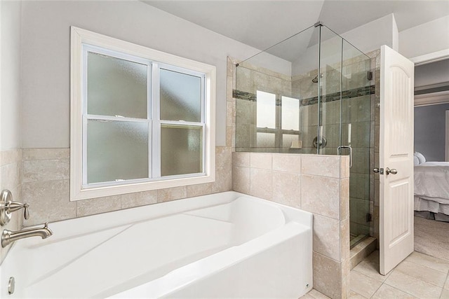 bathroom with tile patterned floors and shower with separate bathtub