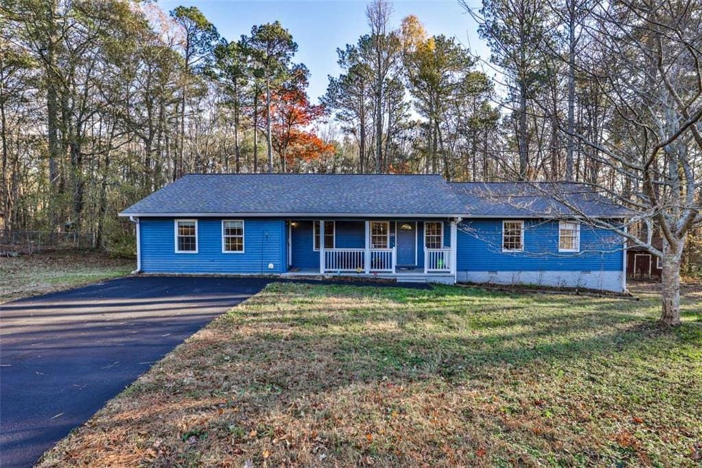 ranch-style home with covered porch and a front lawn