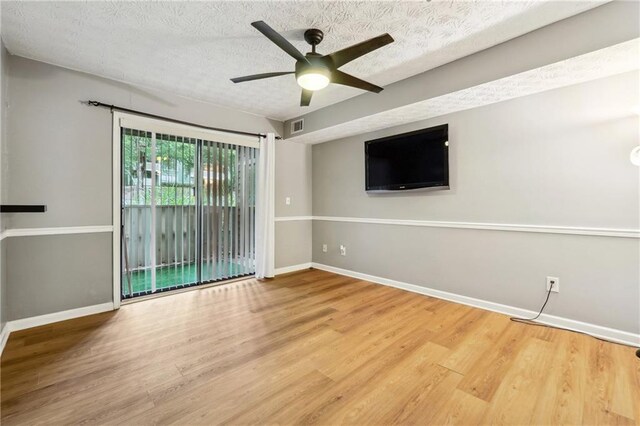 spare room with ceiling fan, wood-type flooring, and a textured ceiling