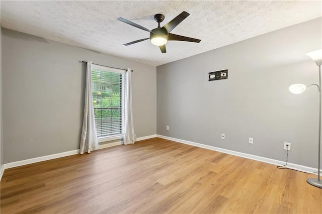 unfurnished room featuring ceiling fan, hardwood / wood-style floors, and a textured ceiling