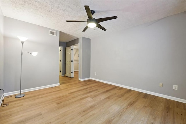 empty room featuring ceiling fan, a textured ceiling, and light wood-type flooring