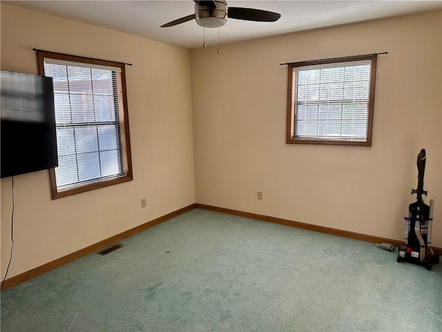 empty room with ceiling fan and light colored carpet