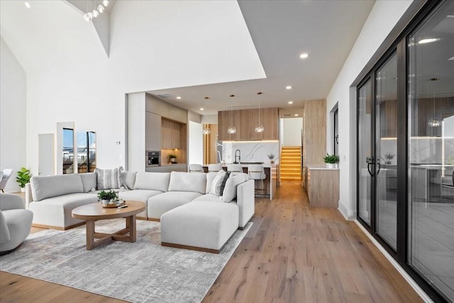 living room featuring light hardwood / wood-style flooring and a high ceiling