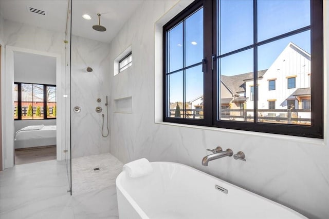 bathroom featuring plenty of natural light and plus walk in shower