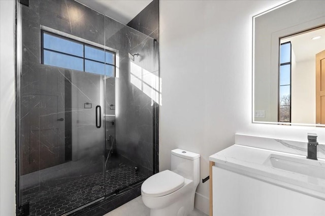 bathroom featuring vanity, toilet, and a shower with shower door