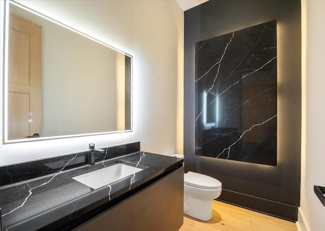 bathroom featuring vanity, hardwood / wood-style floors, and toilet