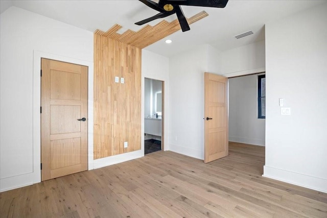 unfurnished bedroom featuring connected bathroom, ceiling fan, and light wood-type flooring