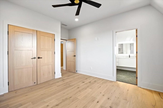 unfurnished bedroom featuring a closet, connected bathroom, ceiling fan, and light hardwood / wood-style flooring