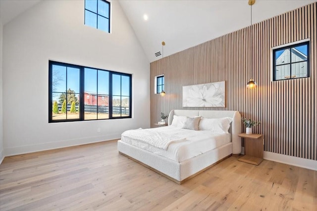 bedroom with high vaulted ceiling and light wood-type flooring