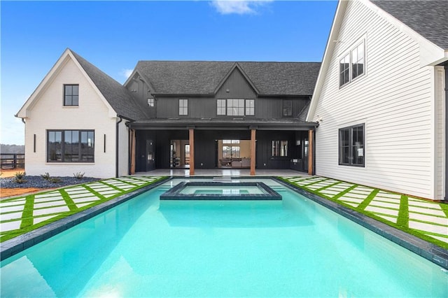 rear view of house with a patio area and a pool with hot tub