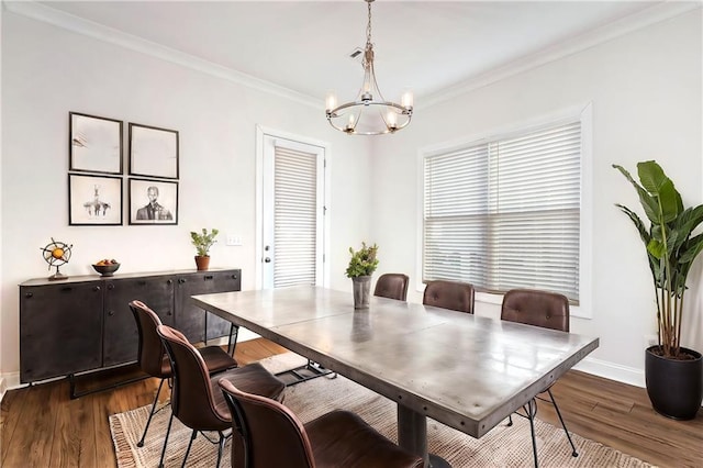 dining room featuring ornamental molding, dark wood-type flooring, and an inviting chandelier