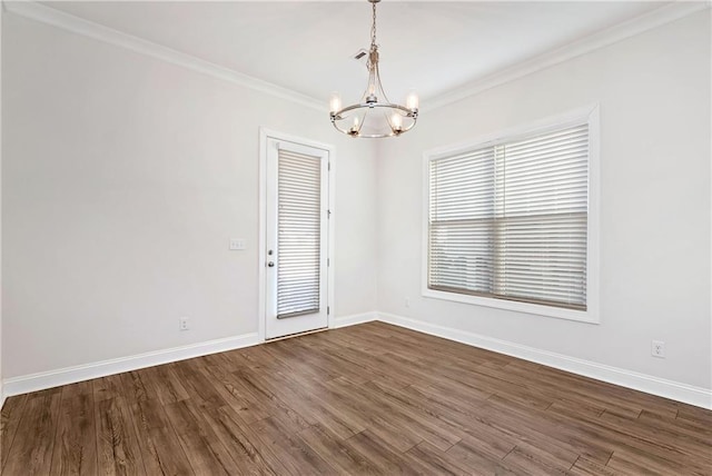 spare room with dark wood-type flooring, an inviting chandelier, and ornamental molding