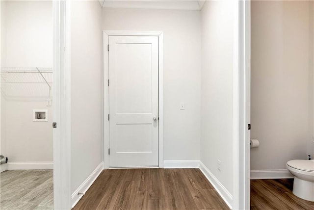 laundry area featuring dark wood-style flooring, baseboards, and laundry area