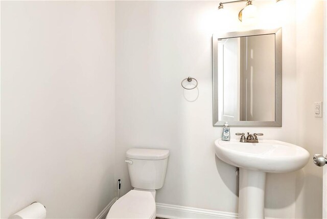 half bath with toilet and baseboards